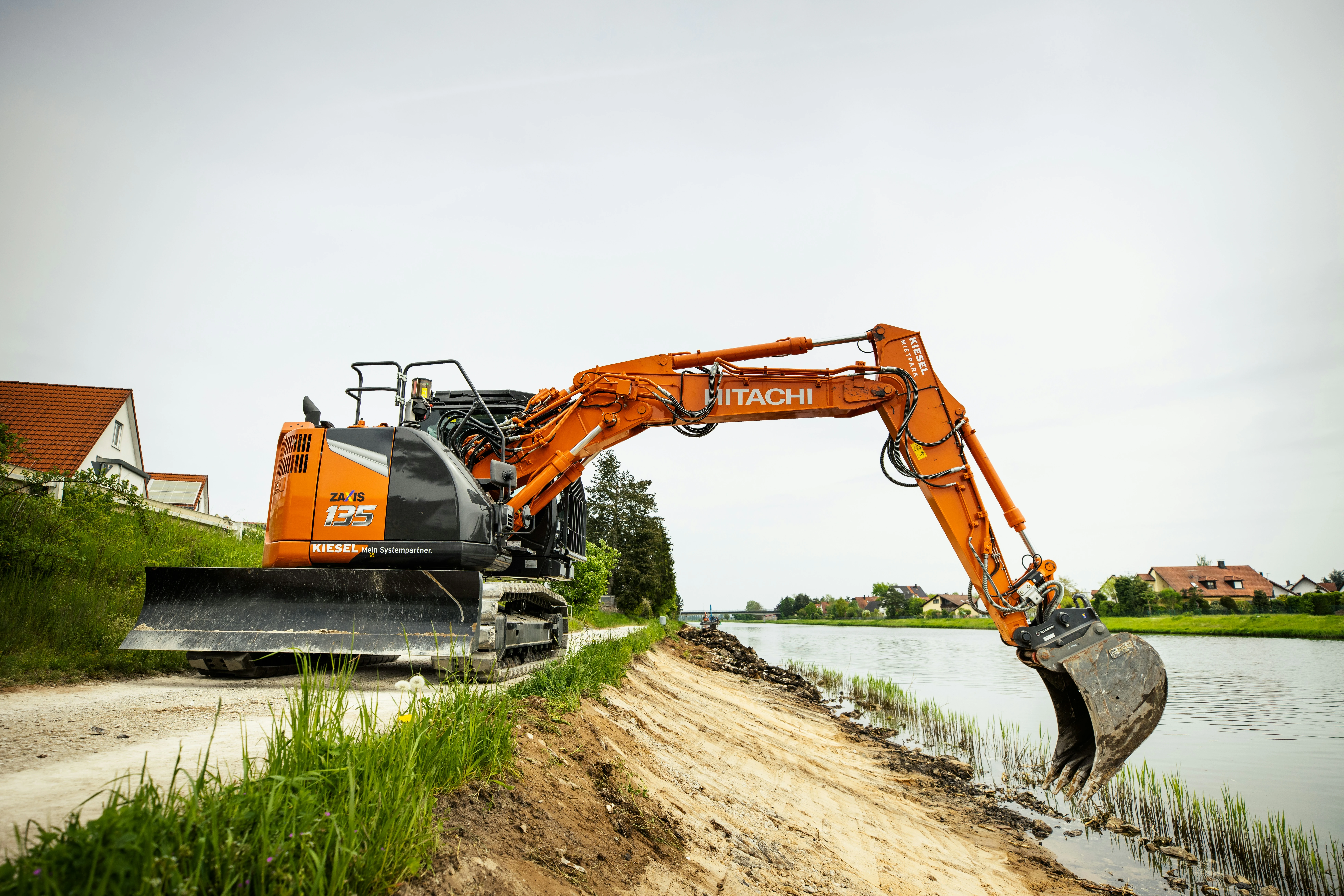 Oranger Bagger auf Baustelle am Wasser